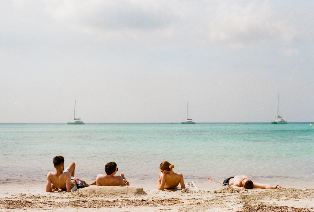 four person lying on beach,