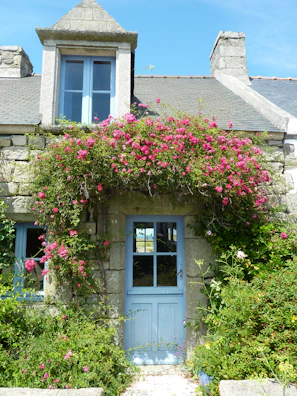 Elegant seaside cottage entrance with fresh flowers and wooden details
