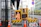 Image of a construction site with bright yellow safety cones and workers in industrial gear.
