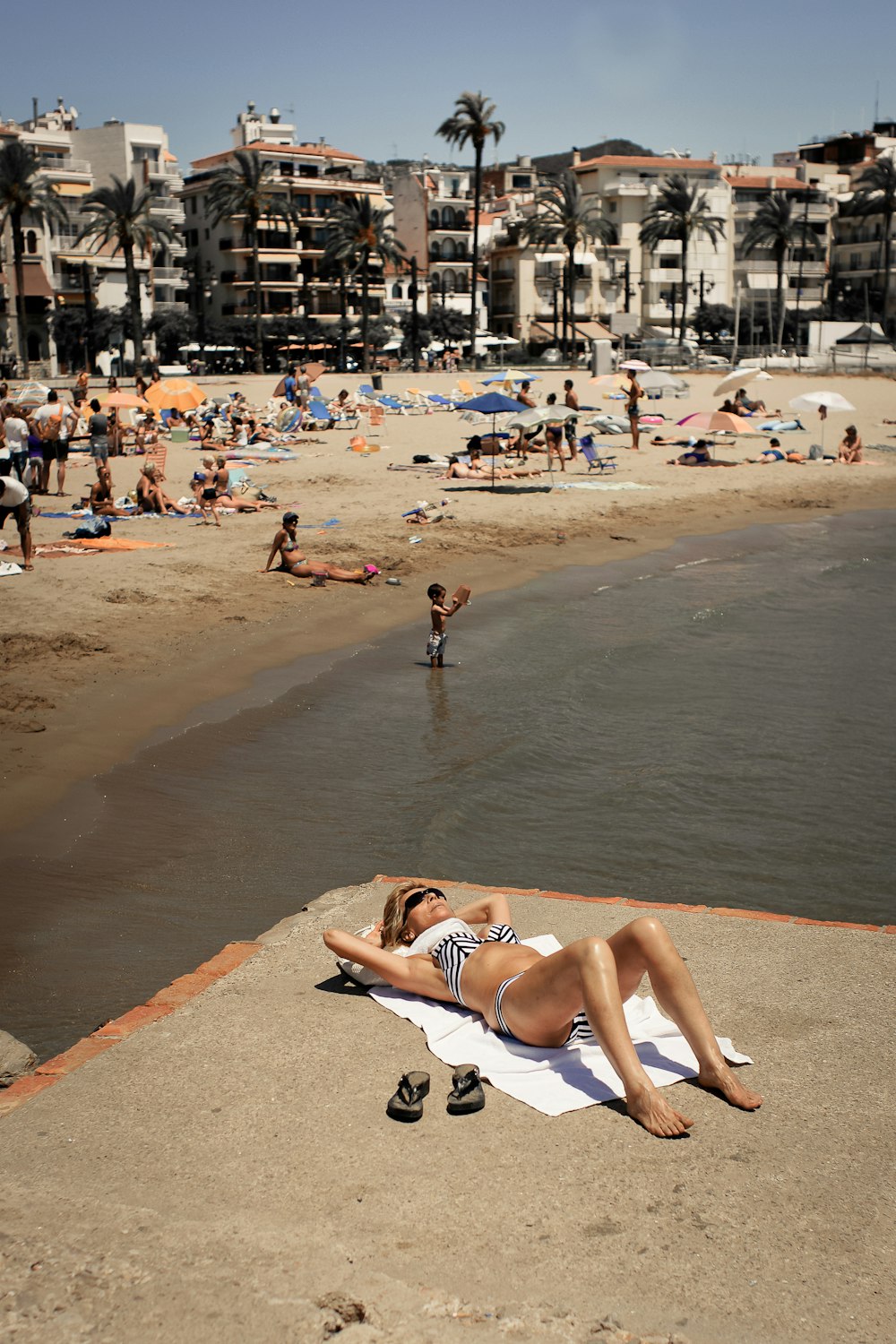 woman wearing black and white swimsuit sunbathing