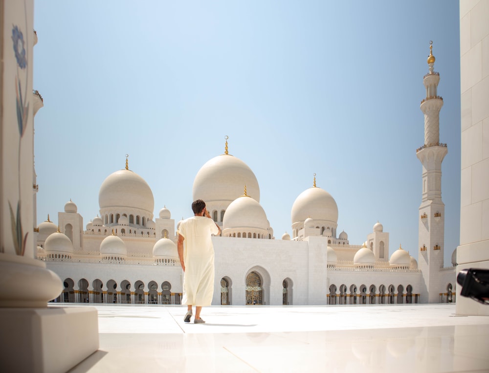 man standing near white mosque