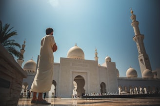 man standing near white mosque