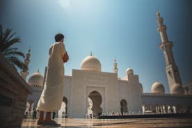 man standing near white mosque