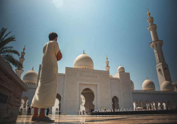 man standing near white mosque