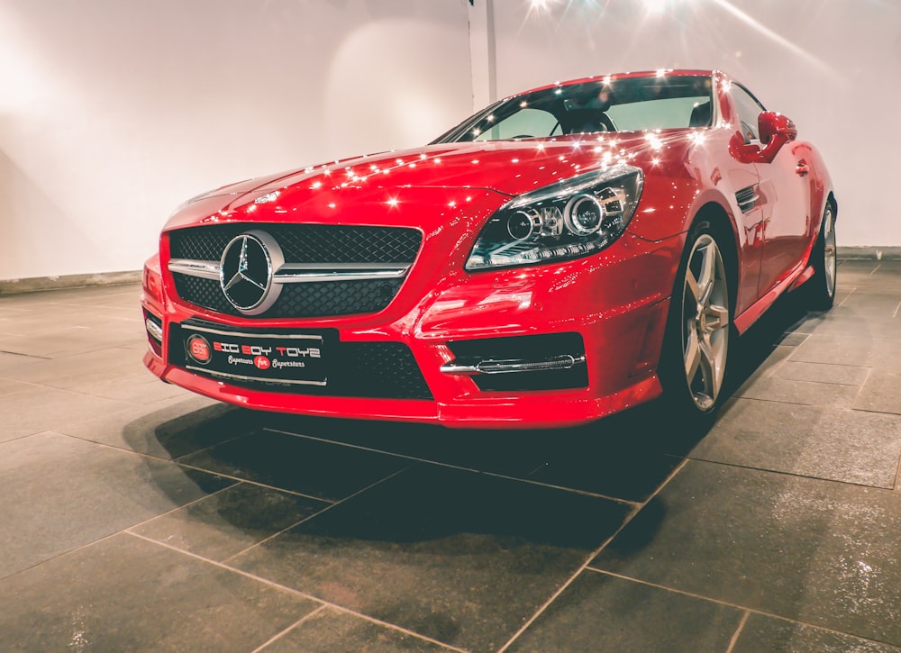 red Mercedes-Benz coupe near wall