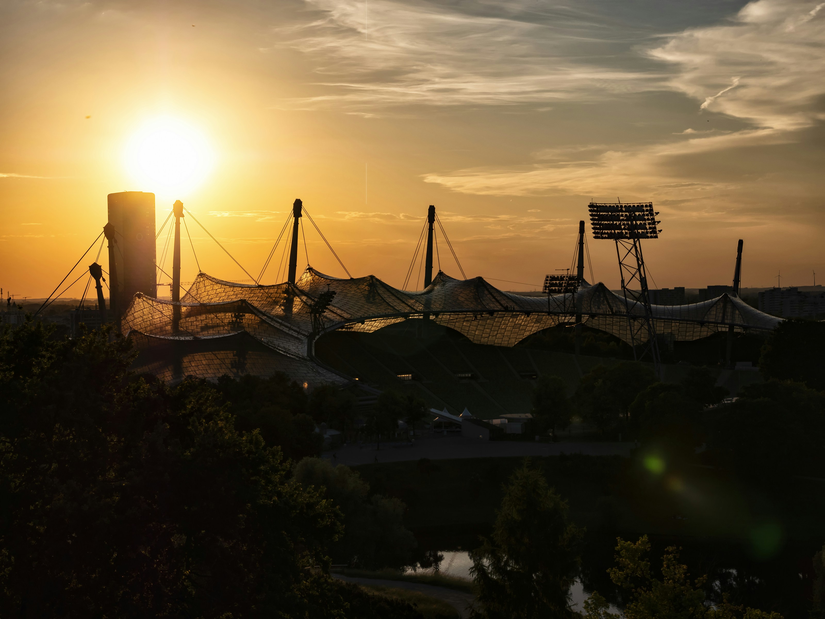 the sun is setting over a baseball field