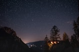 Night view of chalets with gentle outdoor lighting and starry sky.