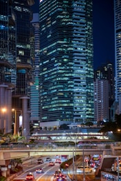 vehicles on road near high buildings at nighttime