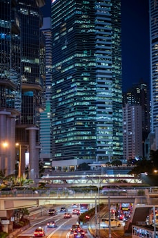 vehicles on road near high buildings at nighttime