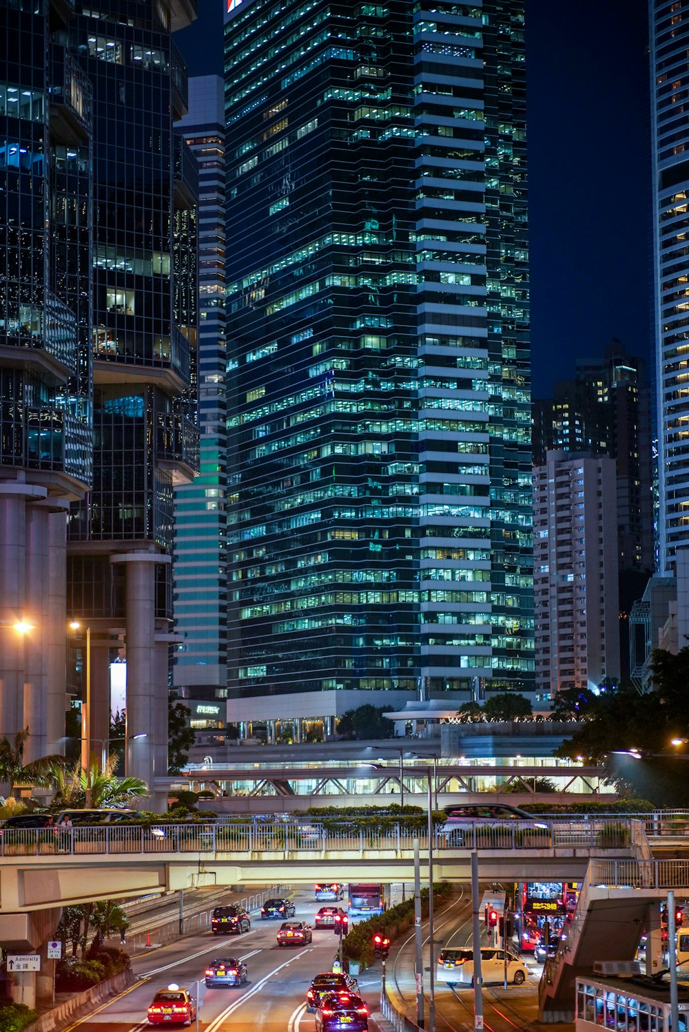 vehicles on road near high buildings at nighttime