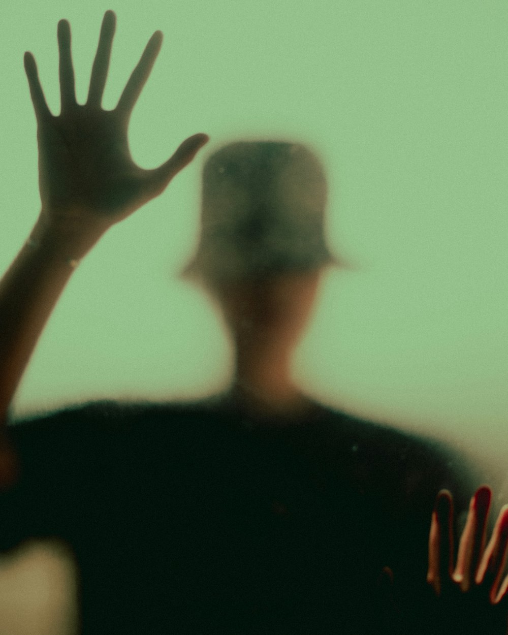 a blurry image of a person with their hands up