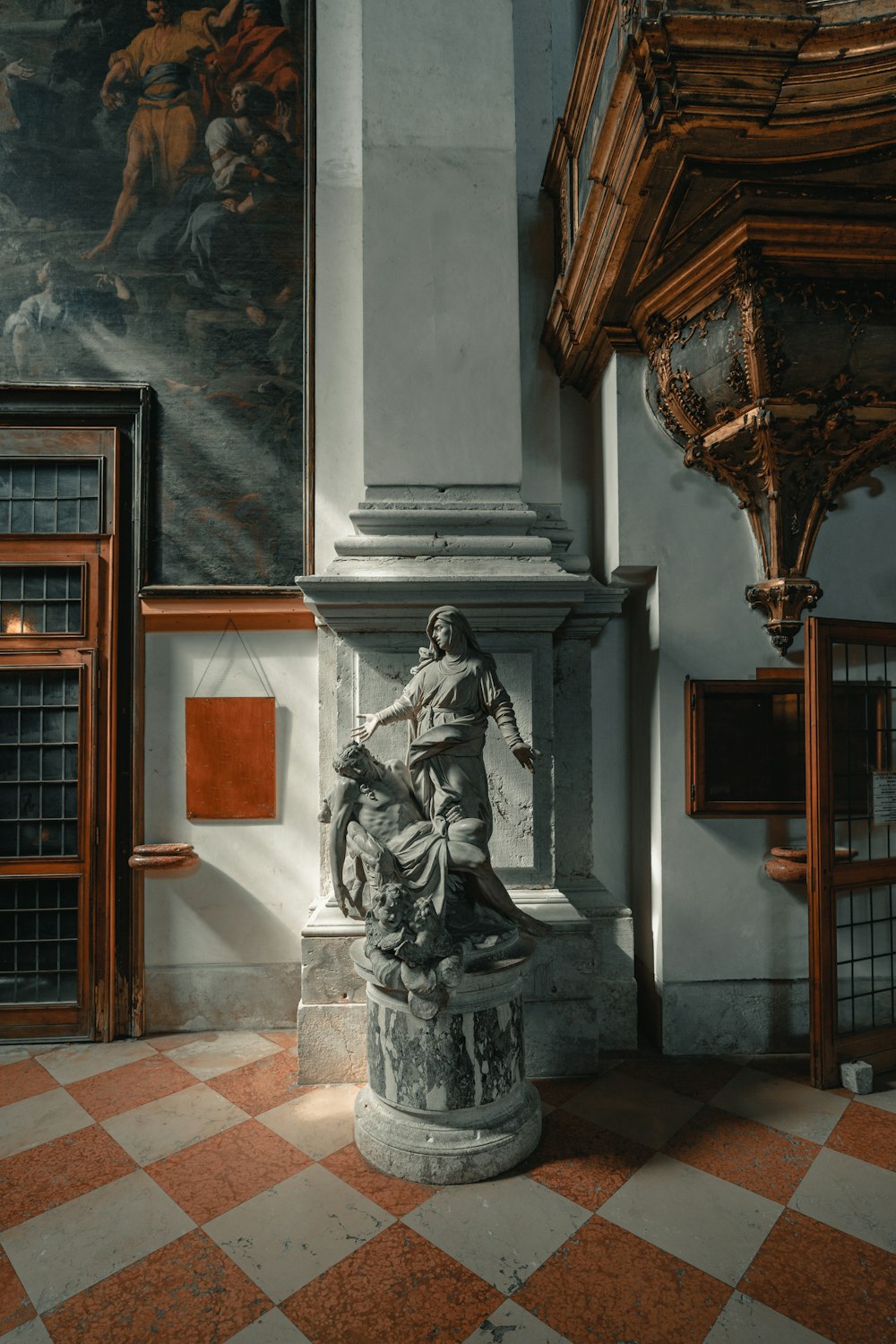 statue beside pillar indoors