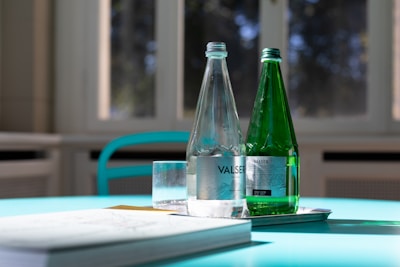 two clear and green glass bottles