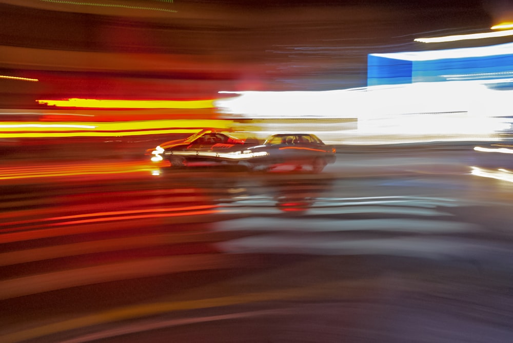 time-lapse photography of two cars passing by a street
