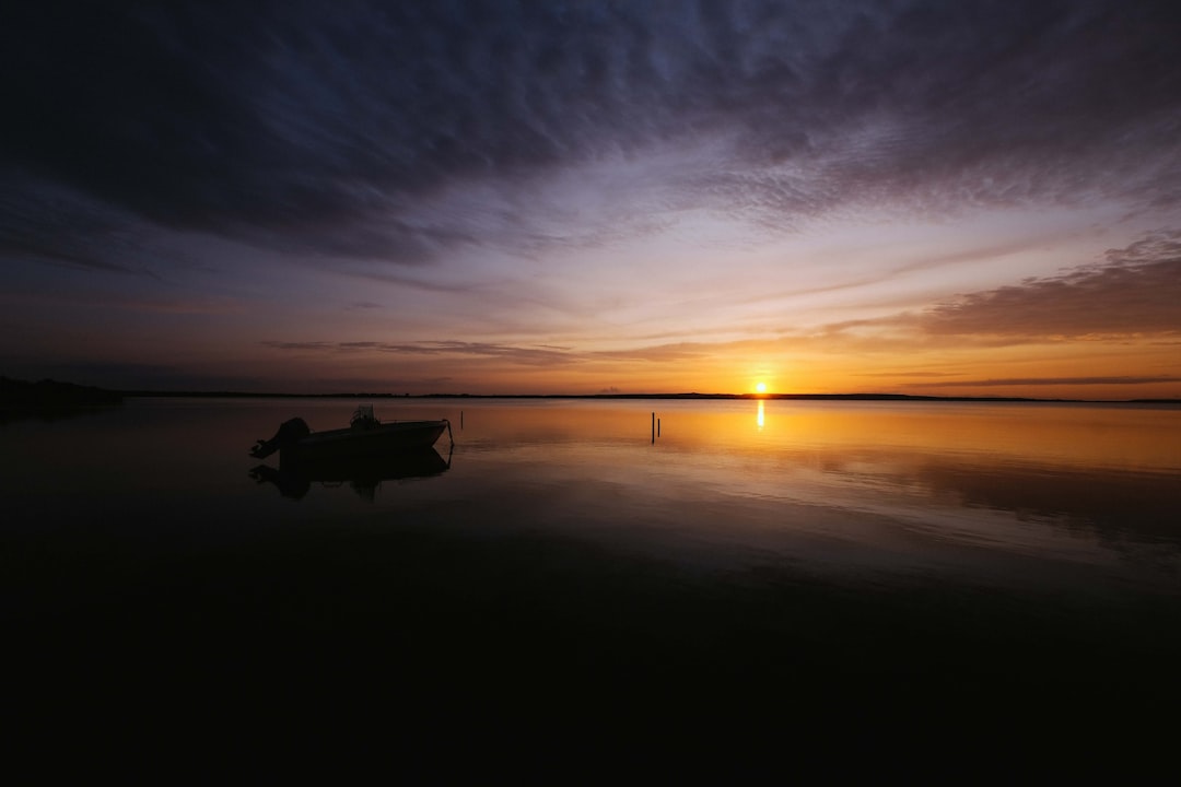 boat in body of water during sunrise