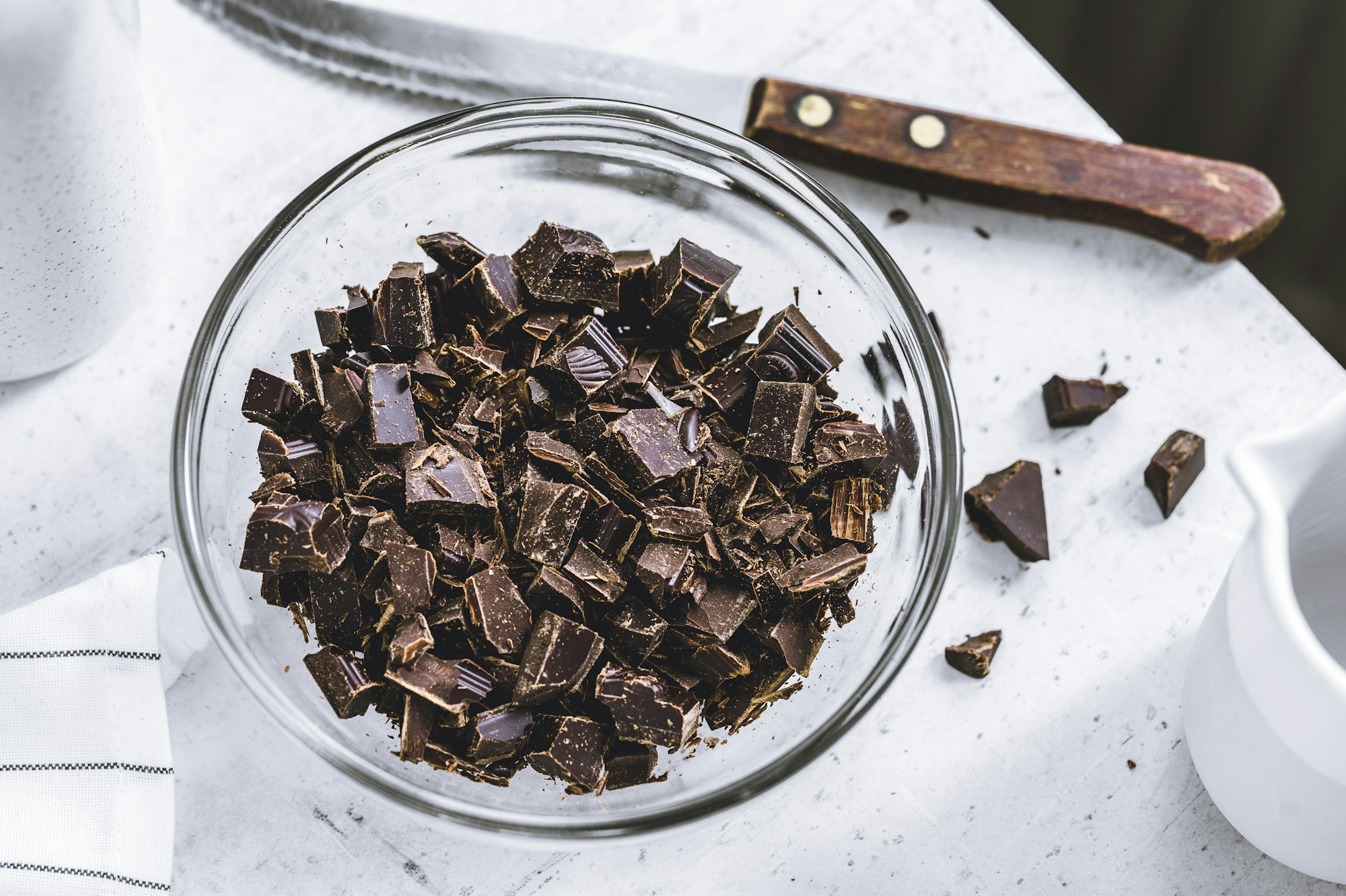Chopped dark chocolate ready for melting on a white background