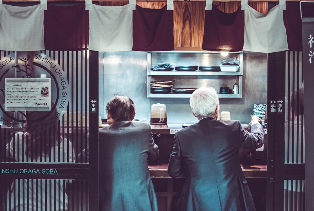 two men and woman sitting inside restaurant