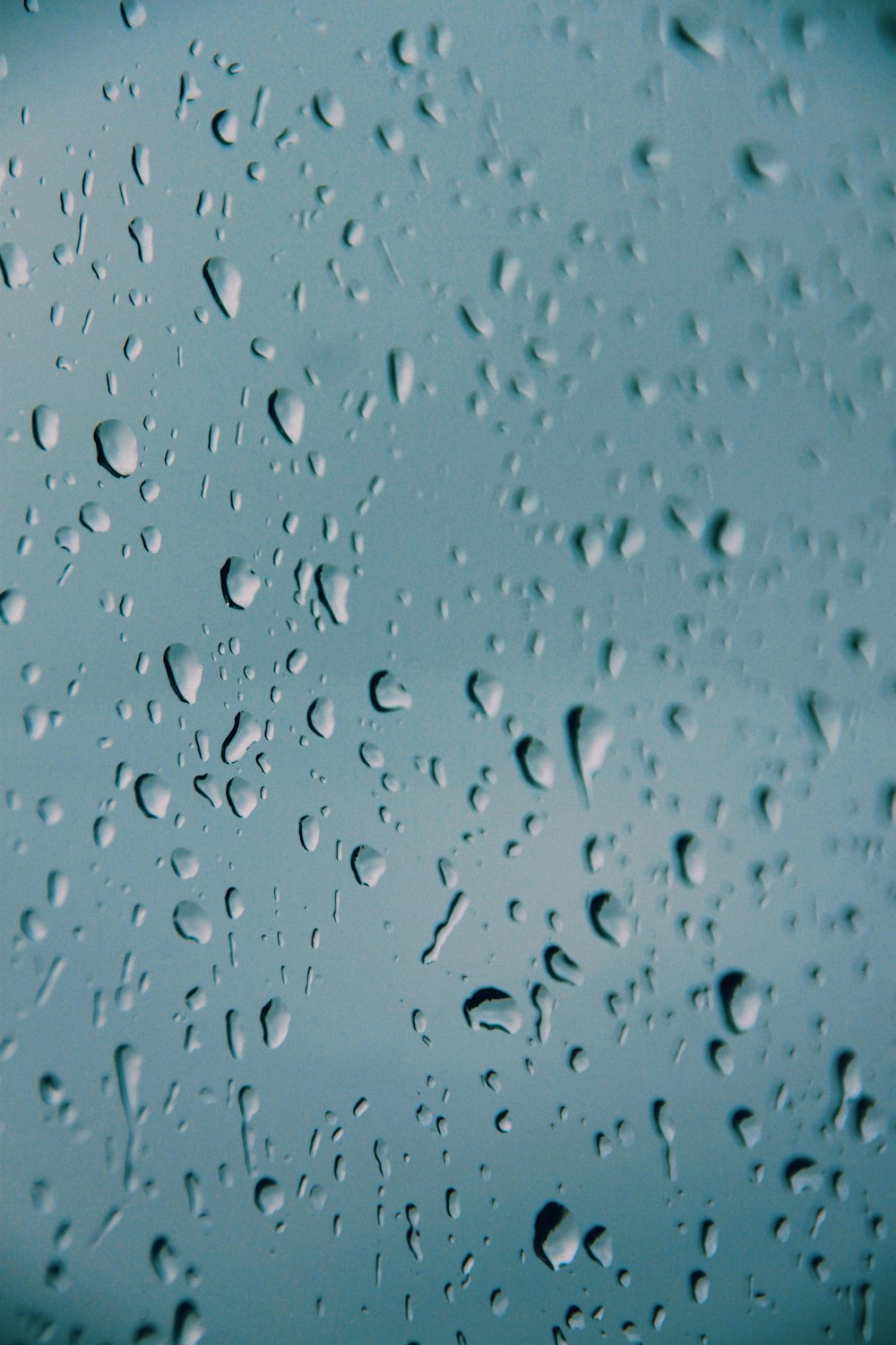 um close up de gotículas de água em uma superfície azul