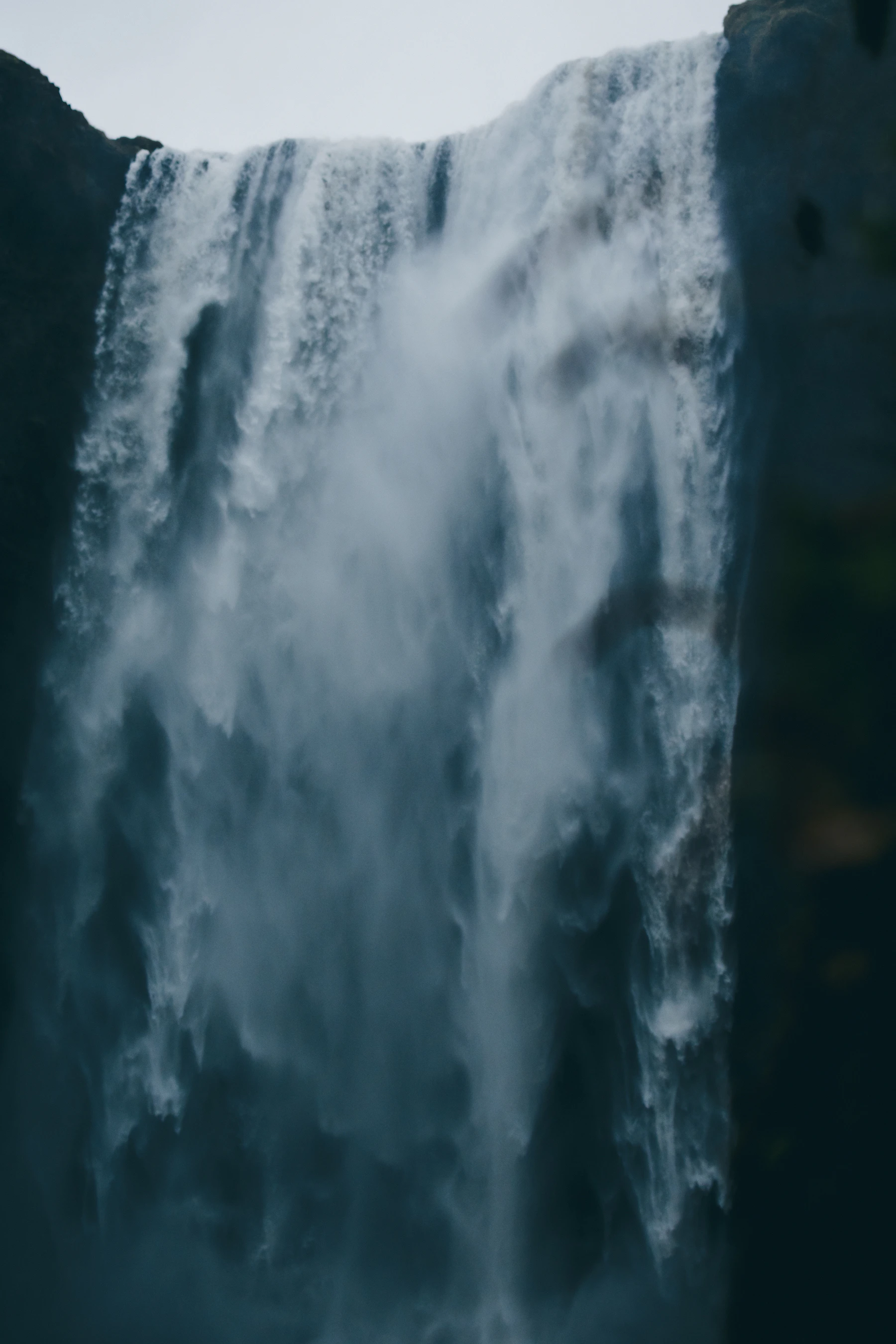 Skógafoss waterfall falling from a dark cliff in Iceland