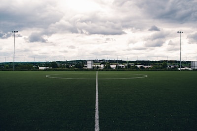 A vibrant sports field covered with lush synthetic turf under a clear blue sky.