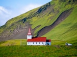 red and white chapel near mountain during daytime