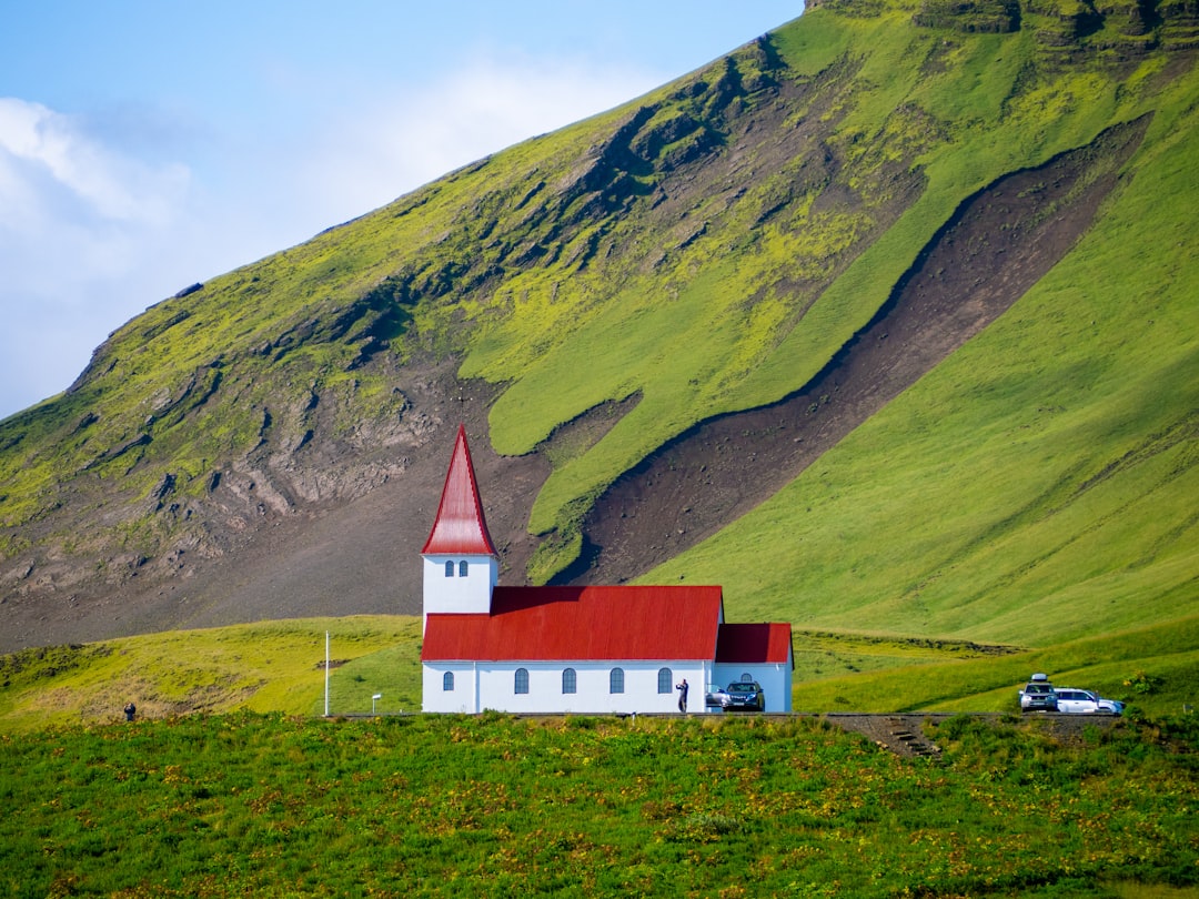 red and white chapel near mountain during daytime