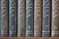 A collection of personalized name numerology reports with golden embossed covers.