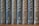 A row of nine vertically arranged books with dark, textured covers, each labeled with numbers and location names in an elegant serif font. The titles appear to be in a consistent style with gold embossing, providing a classic and scholarly appearance.