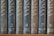 A row of nine vertically arranged books with dark, textured covers, each labeled with numbers and location names in an elegant serif font. The titles appear to be in a consistent style with gold embossing, providing a classic and scholarly appearance.