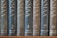 A row of nine vertically arranged books with dark, textured covers, each labeled with numbers and location names in an elegant serif font. The titles appear to be in a consistent style with gold embossing, providing a classic and scholarly appearance.