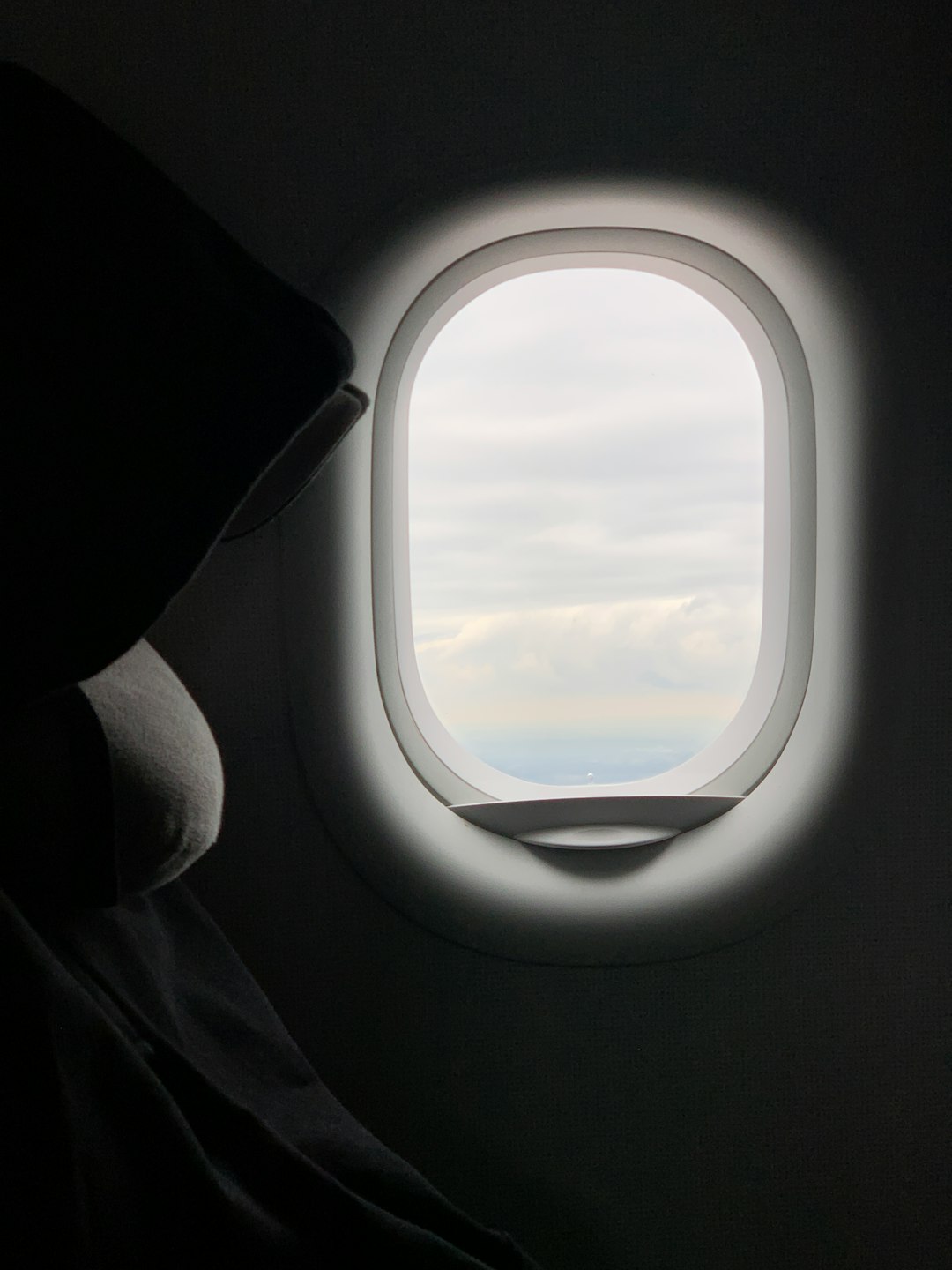oval white framed airplane window close-up photography