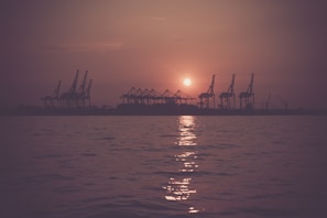 A sunset view over the Nile with containers being transported, reflecting our deep roots in Egypt since 2009.