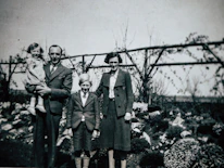 A vintage photo of the Walter family gathered around a picnic table outdoors.