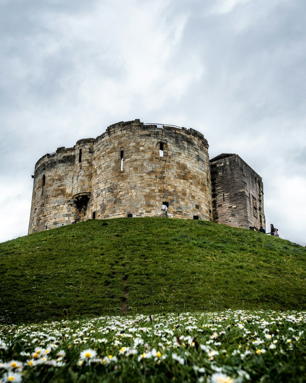 Castelo cinzento no topo da colina durante o dia