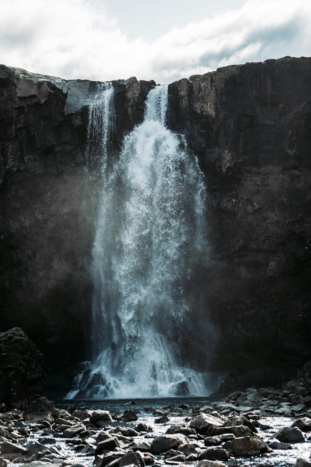 cascades sous ciel blanc et gris pendant la journée