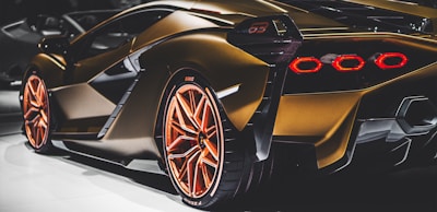 gold coupe parked on white surface
