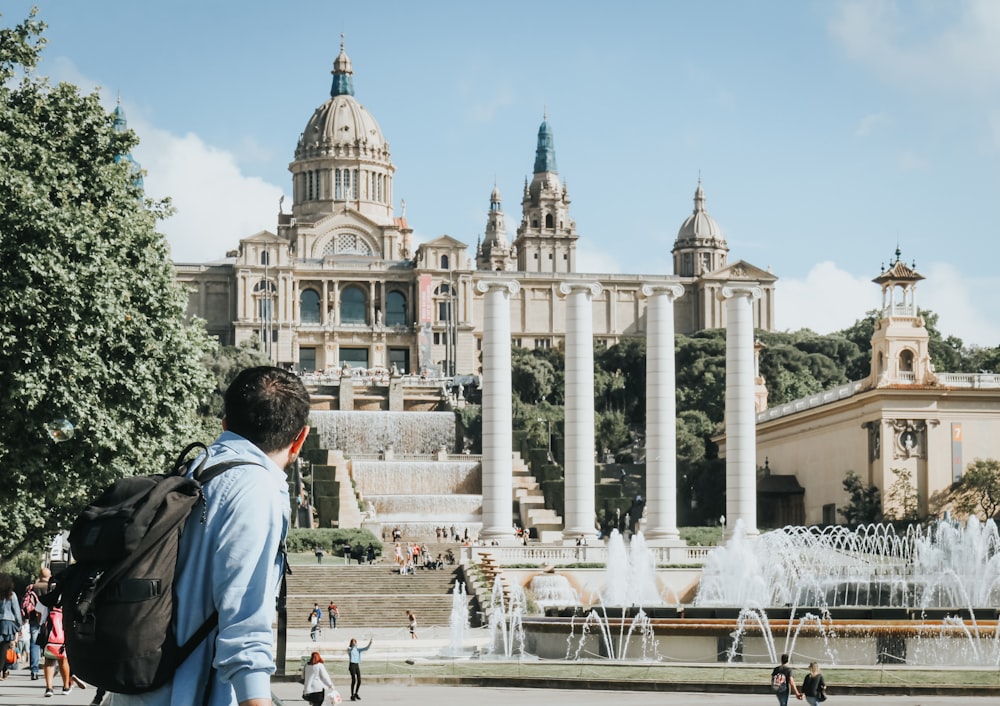 personas cerca del Museu Nacional d'Art de Catalunya en Barcelona bajo el cielo azul y blanco durante el día