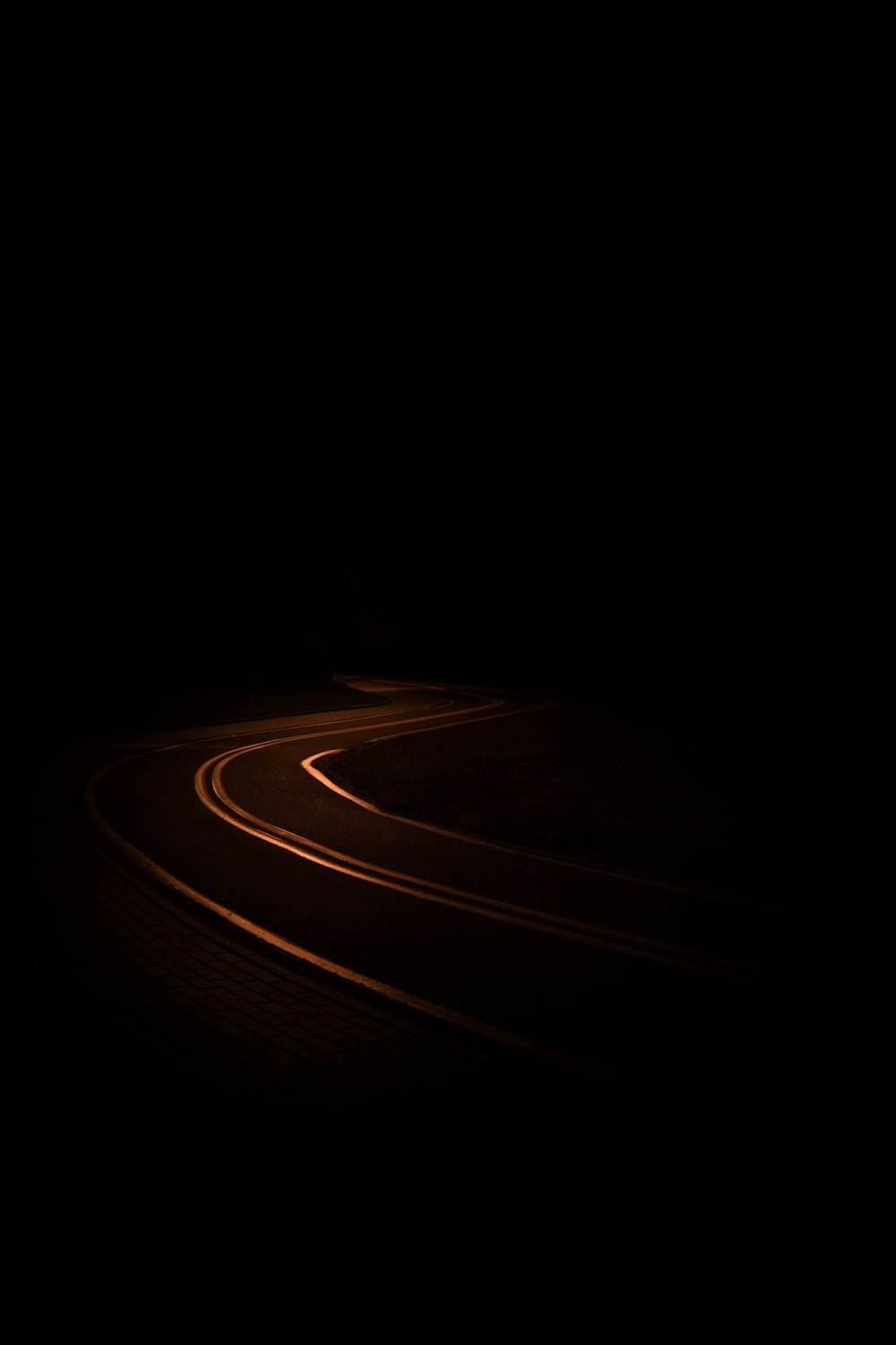 a car driving down a dark road at night