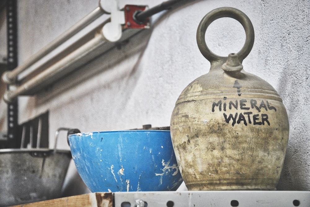 bol bleu et carafe d’eau minérale blanche