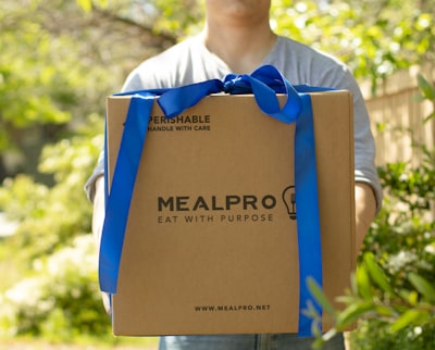 person carrying mealpro box box teams background