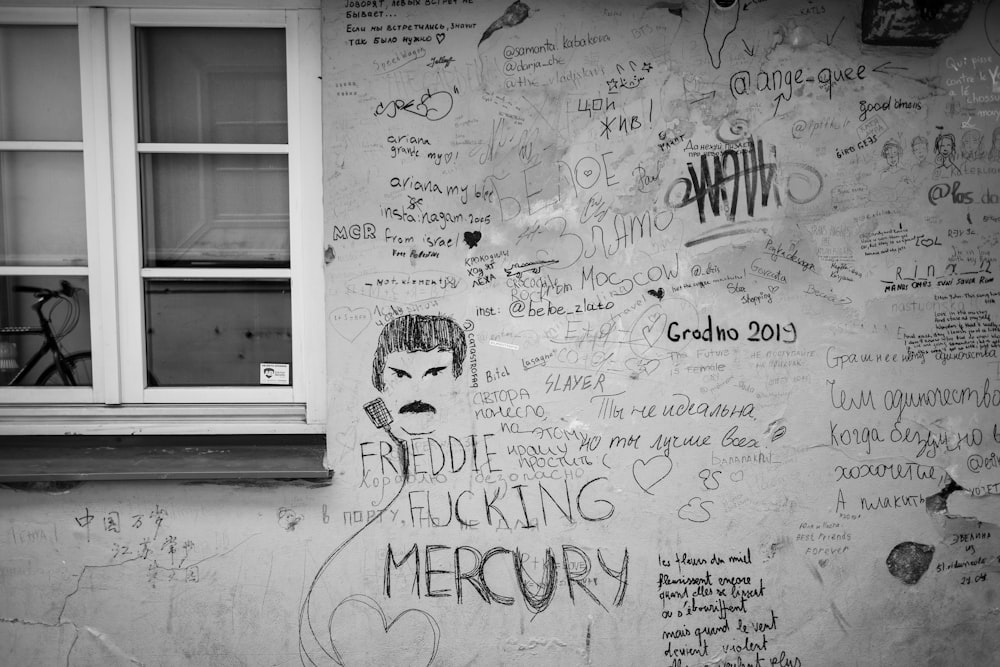 a wall with writing on it and a bicycle parked next to it