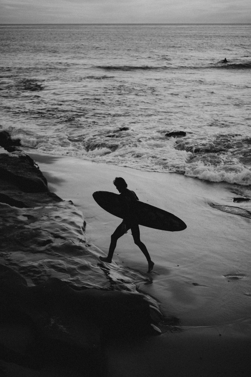 Silueta de hombre que lleva tabla de surf