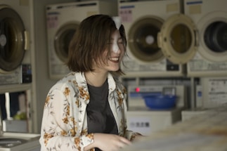 A friendly customer service representative smiling at a laundry service counter.