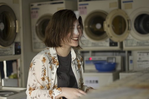 A friendly customer service representative smiling at a laundry service counter.