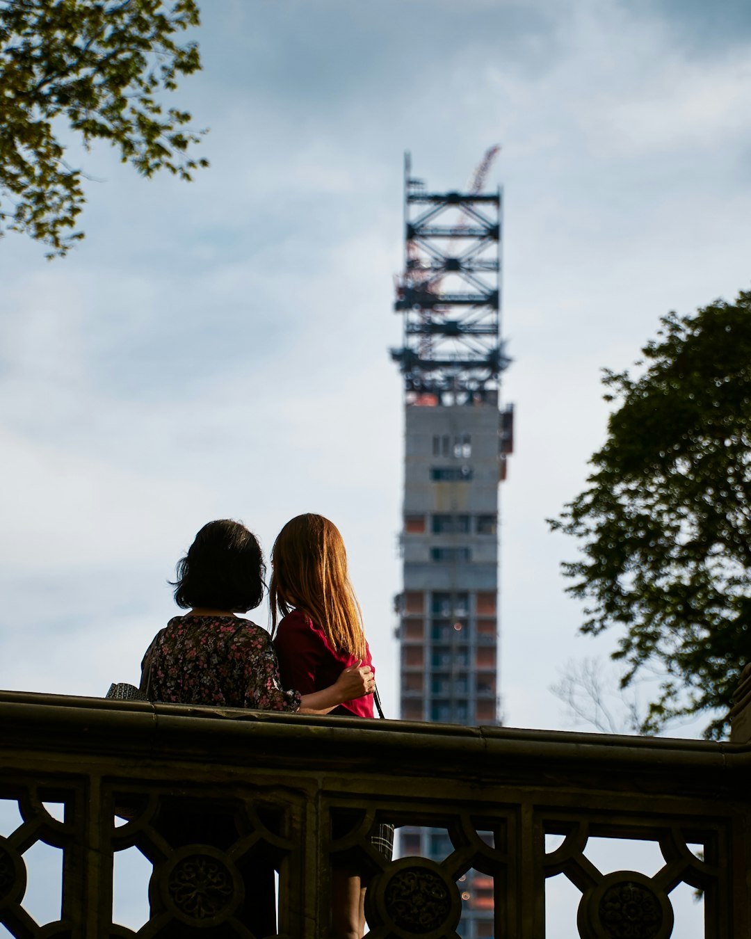 two persons facing towards buildings