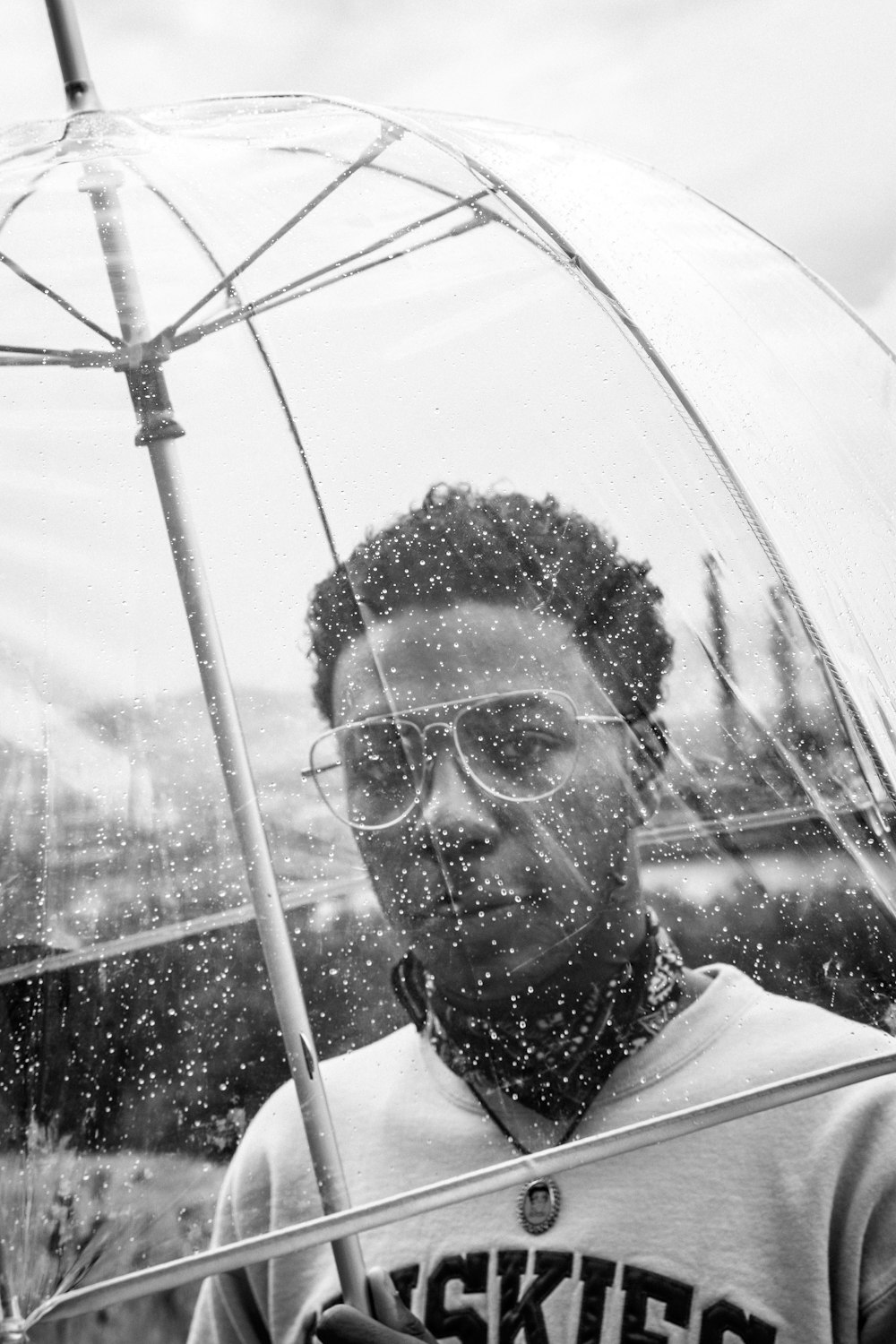 greyscale photography of man holding umbrella