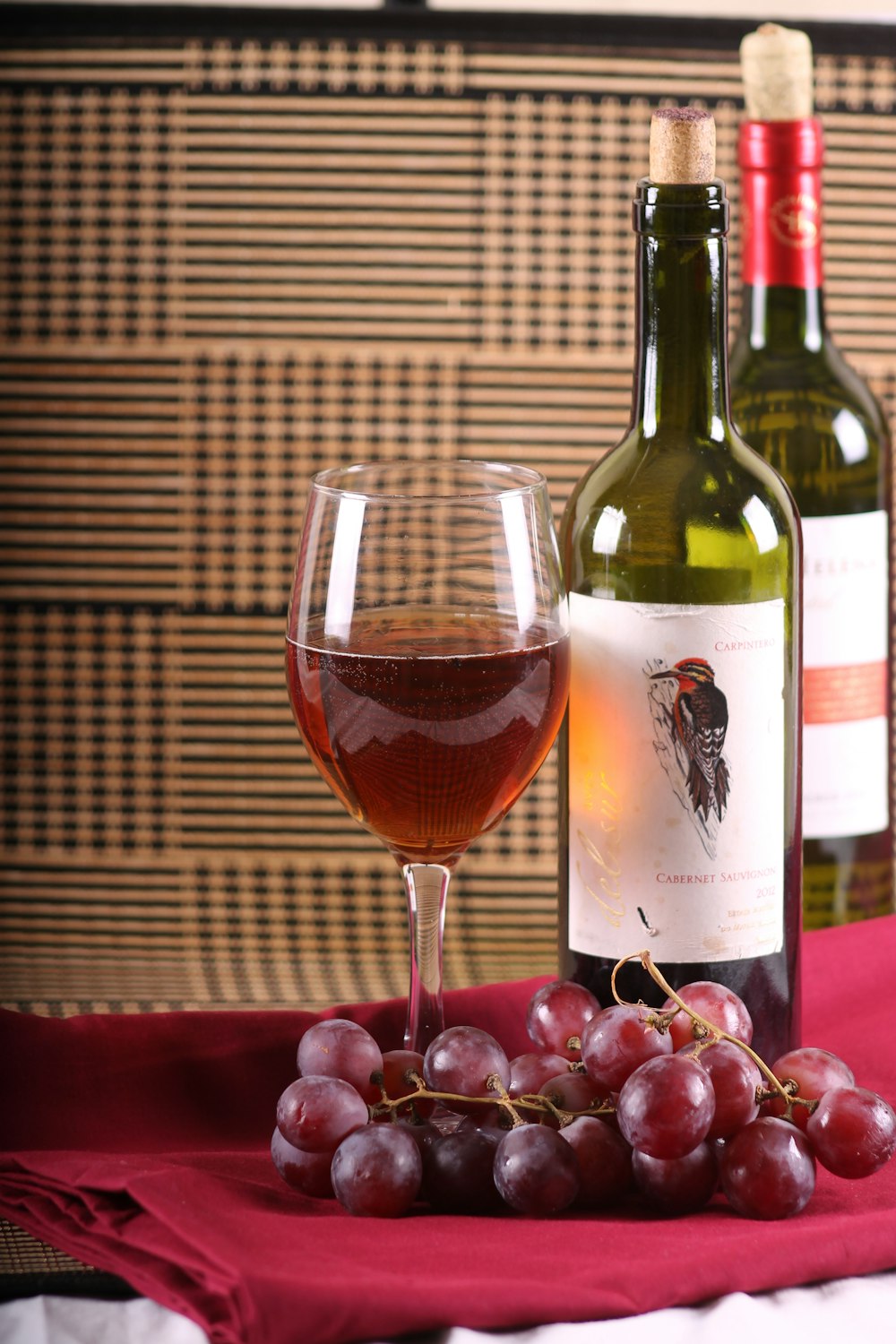 clear tulip wine glass beside two wine bottles