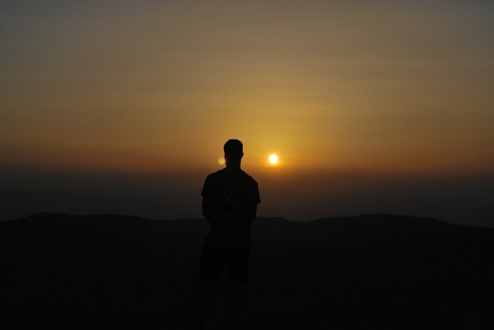 silhouette of man on high ground