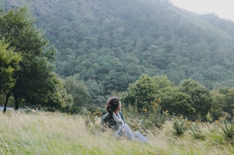 A person sitting peacefully in nature, reflecting.
