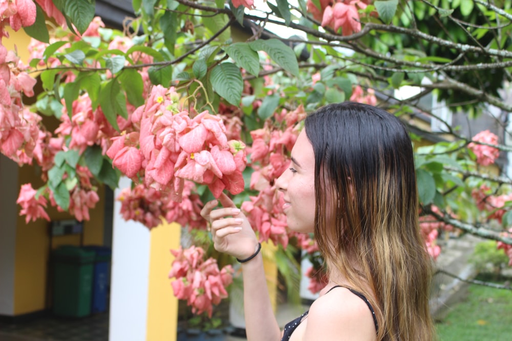 mulher segurando a flor cor-de-rosa da pétala